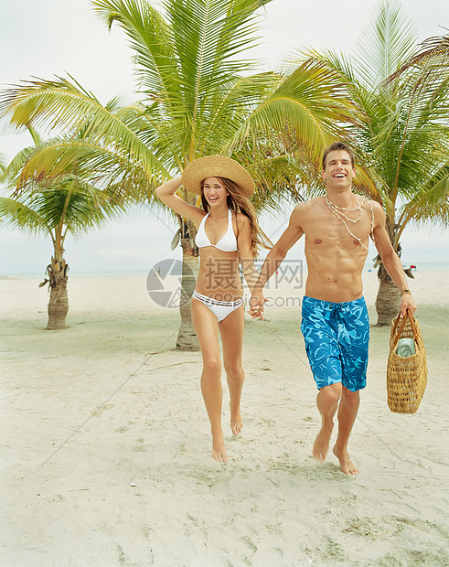 夫妇在热带海滩上行走图片