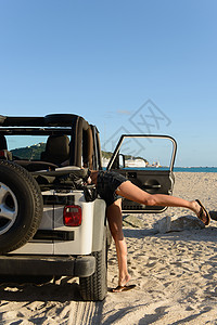 在海滩上用吉普车搜查的妇女图片