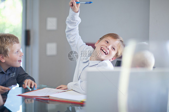 在办公桌上扮演商人的男孩图片