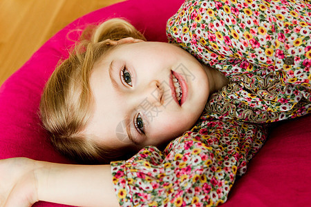 微笑的女孩躺在枕头上图片