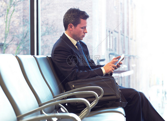 在机场使用手机的商人图片