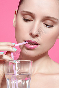 妇女用吸管喝水的特写镜头图片