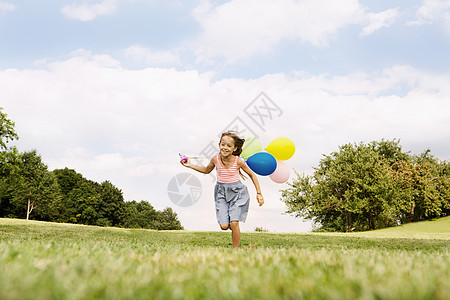 女孩拿着气球在草地上奔跑图片
