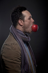 嘴里有苹果的人肖像图片