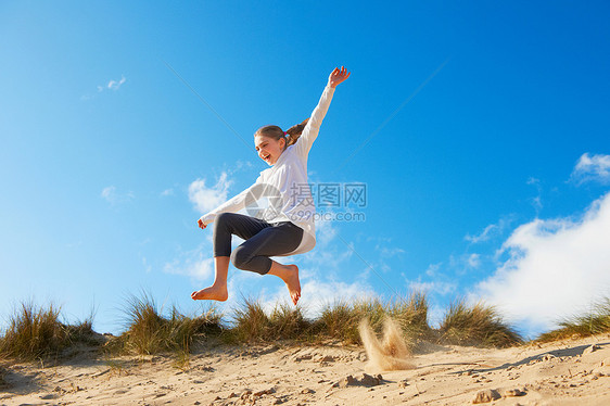 女孩在海滩上跳跃图片