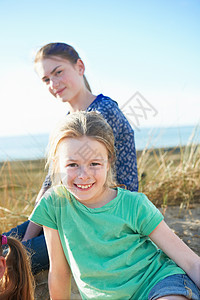 两个女孩在沙滩上微笑图片
