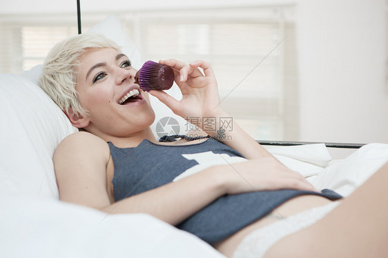 躺在床上吃蛋糕的女人图片