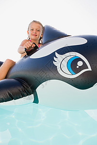 鲸鱼女孩女孩在充气鲸鱼上玩耍背景