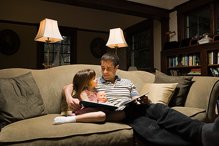父亲和女儿在沙发上看书图片