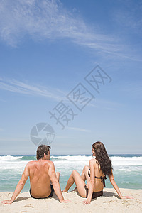 坐在沙滩上的年轻夫妇图片