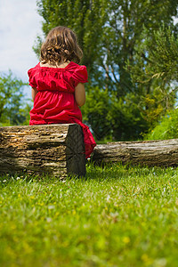 一个女孩坐在木头上图片
