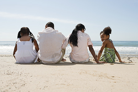 一家人坐在海滩上图片