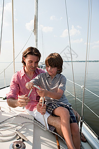父亲和儿子在游艇上绳图片