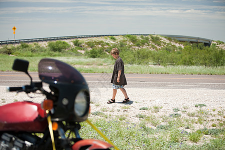 男孩路过摩托车图片