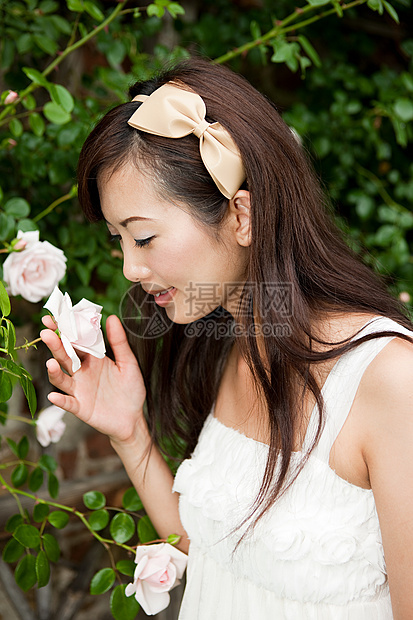 美女在闻着花香图片