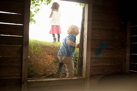 通过木制窗框的小孩图片