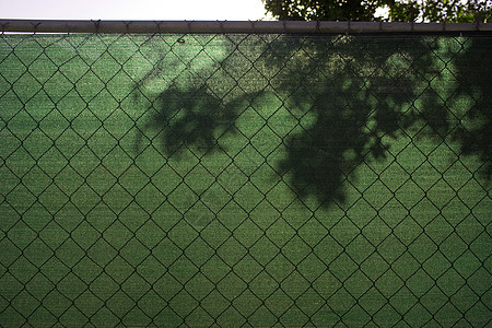 铁丝围栏上的树影图片