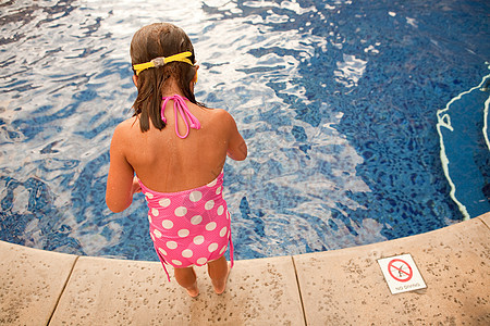 年轻女孩站在游泳池边图片