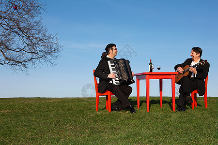 两个男人在户外玩手风琴和吉他图片