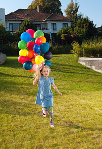 女孩拿着气球在草坪上奔跑图片