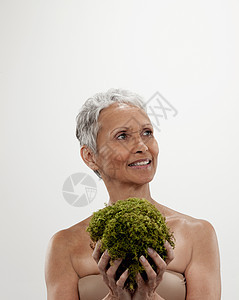 手捧绿植的中年妇女图片