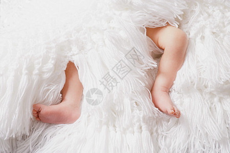 白毯子上婴儿男孩的腿图片