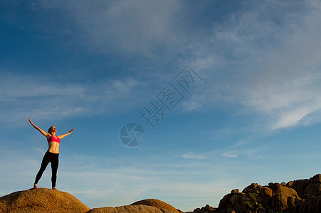 站在沙漠中双臂张开的年轻女孩图片