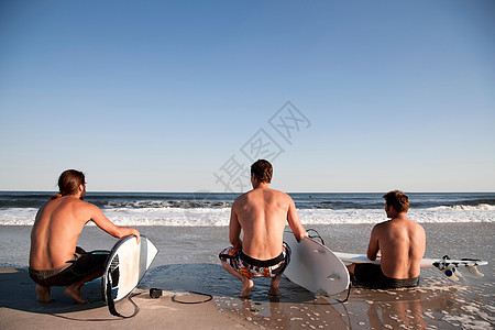 海滩上三个冲浪者图片
