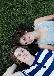 躺在草地上的青少年夫妇图片