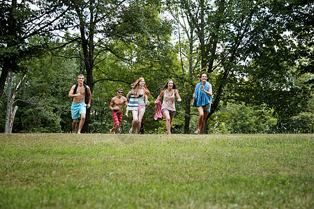 五个朋友在草地上奔跑前行图片