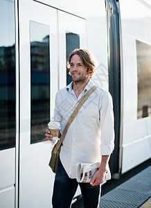 火车站拿着咖啡行走的男人背景图片