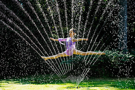 草坪中翩翩起舞的芭蕾舞演员图片