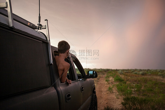 男孩向车窗外看风景图片