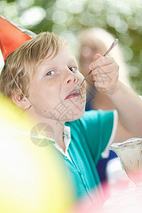 男孩在派对上吃冰淇淋圣代图片