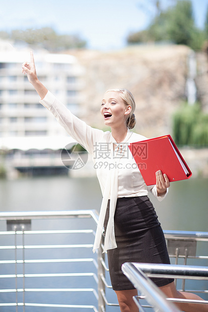 从阳台挥手的女商人图片