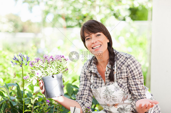 花园中的妇女给植物浇水图片