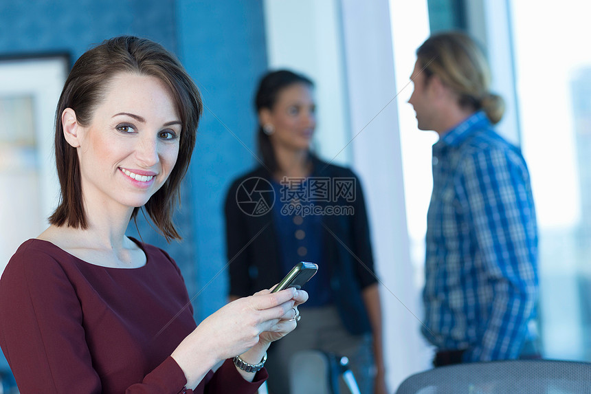 在办公室使用手机的女商人图片