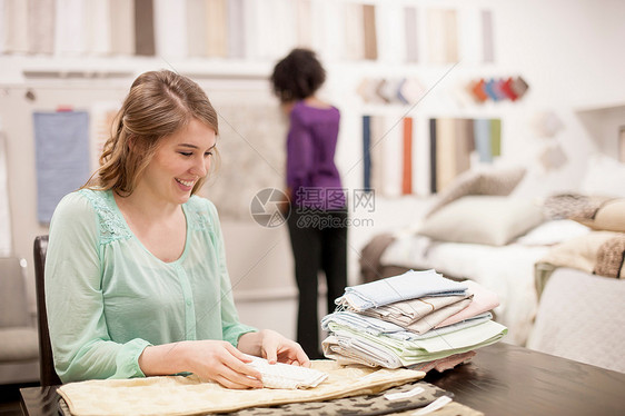 坐在桌子上整理布料的女人图片