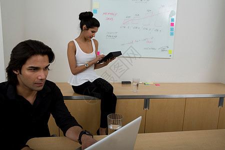 男女学生坐在教室用笔记本电脑图片