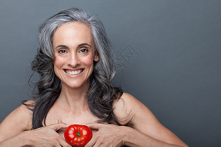手拿番茄的中年妇女图片