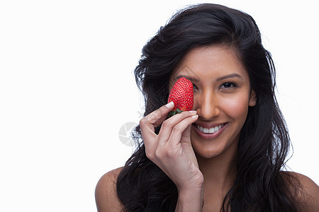 年轻女孩用草莓遮住眼睛图片