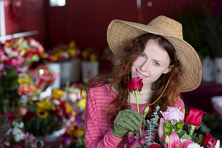 美女在花店里闻着花香图片