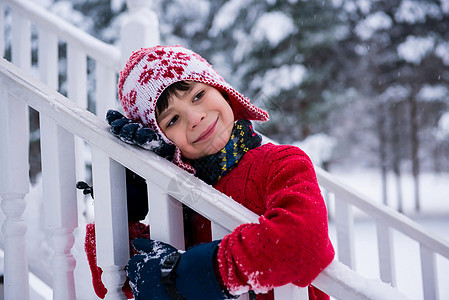 男孩在雪中拥抱栏杆图片