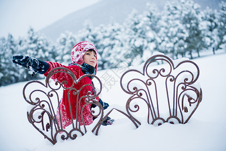 男孩坐在雪中的椅子上图片