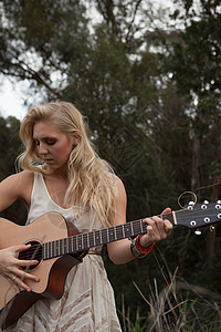 在森林里弹吉他的女人图片