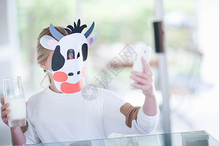 戴着奶牛面具喝牛奶拍照的女孩图片