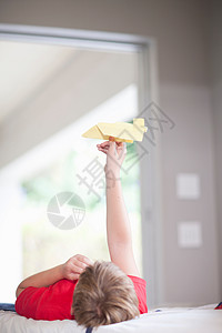 男孩在床上玩纸飞机图片