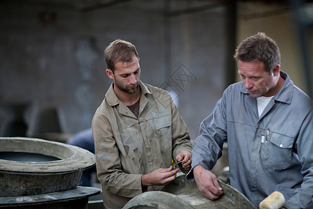 在陶瓷厂检查模具的工人图片
