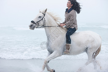 妇女在海滩骑马图片