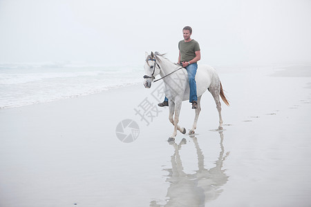 男人在海滩骑马图片